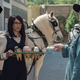 Eugene (Josh McDermitt) points at Max's (Margot Bingham) ice cream cones as she stands in front of a horse-drawn ice cream truck in The Walking Dead.